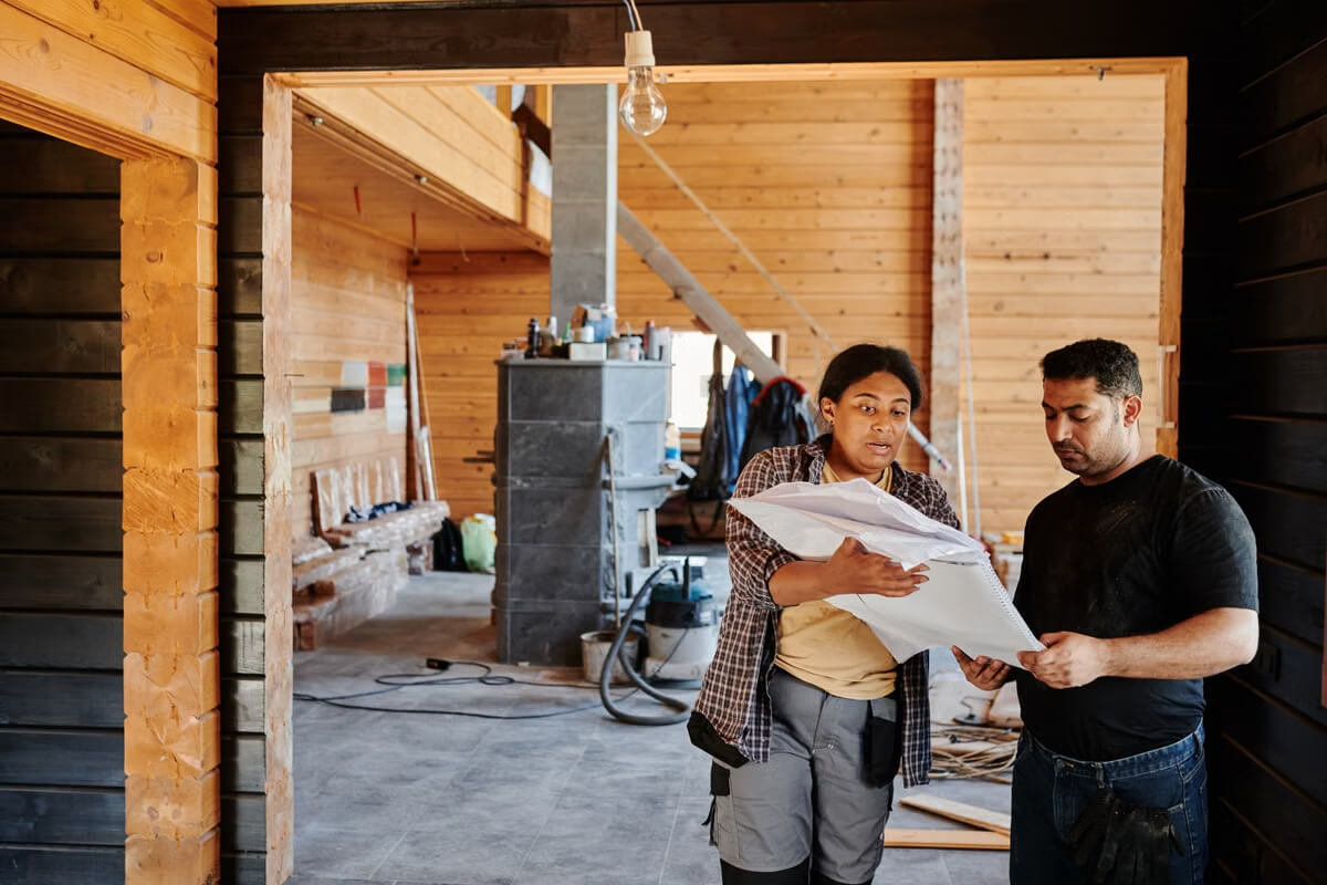 Construction professionals reviewing renovation plans inside an active interior project